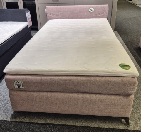 Boxspringbett „Nottingham“ in altrosa-farbenem Stoff mit Bonell-Federkern-Matratze und Topper, präsentiert in einem stilvollen Ausstellungsraum.
