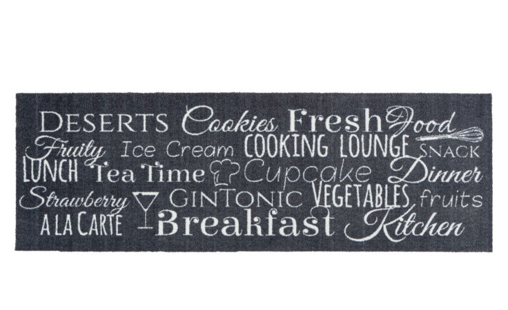 Astra Fußmatte Miabella 50x150 cm: schwarzer Teppich mit weißen Food-Worten, ideal für Küche oder Frühstücksbereich.