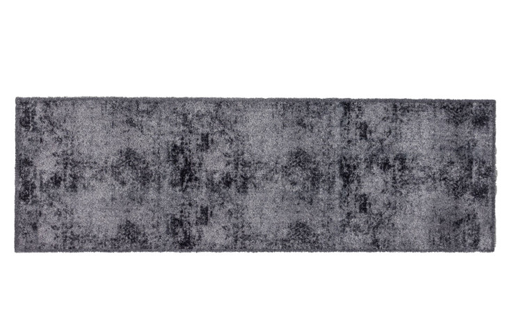 Astra Fußmatte Pure und Soft 50x150 cm aus Polyamid mit einem dezenten dunklen abstrakten Muster auf weißem Hintergrund.