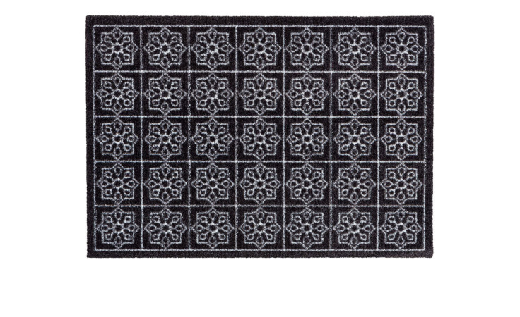Astra Fußmatte Miabella 50x70 cm mit sich wiederholendem weißen geometrischen Blumenmuster auf schwarzem Hintergrund.