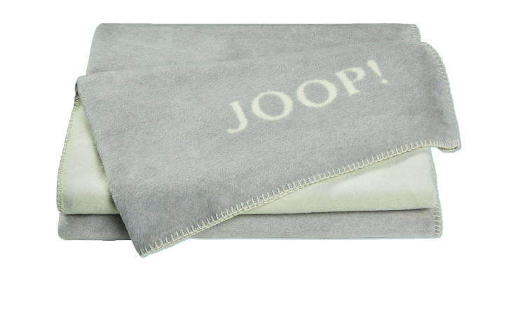 JOOP! Wohndecke Uni-Doubleface 150x200 cm aus grauer Baumwolle mit weißem Logo und dekorativer Kettelnaht.