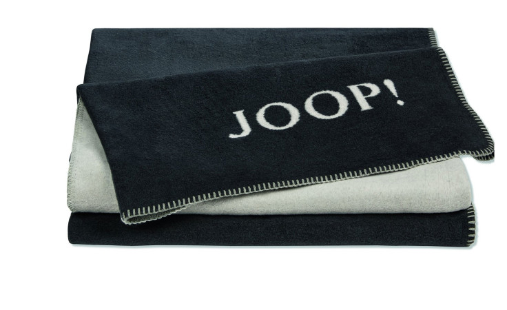 Eine gefaltete schwarz-graue JOOP! Wohndecke Uni Doubleface 150x200 cm mit "JOOP!" in weißer Schrift.