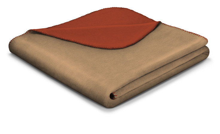 Das Biederlack Wendeplaid Basic Soft 150x200cm hat eine hellbraune Außenseite, eine rote Innenseite und rote Randnähte.