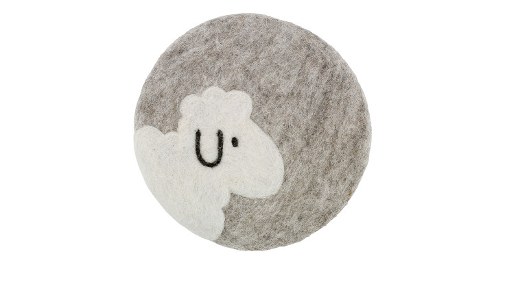 Der Untersetzer Lana 21 cm ist ein runder grauer Filzuntersetzer mit weißem Schafsmotiv, hergestellt aus weicher Schafwolle.