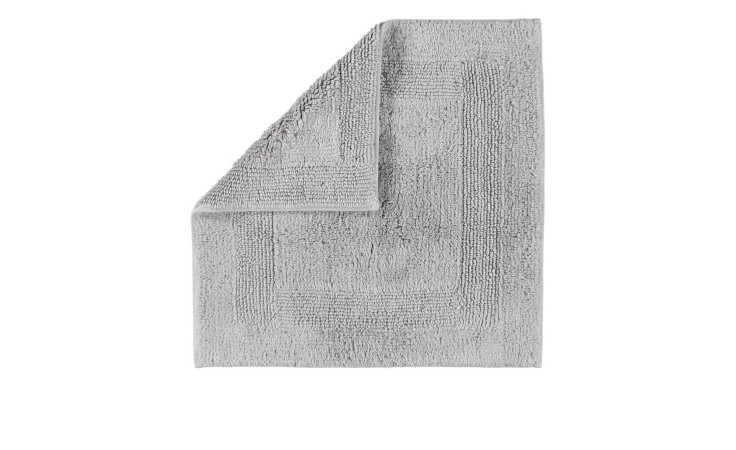 Ein gefalteter Cawö Wende-Badteppich 60 x 60 cm in platinfarben grau mit einem strukturierten Rand, auf weißem Hintergrund.