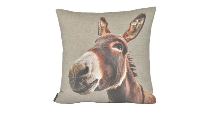 Eine beige Kissenhülle Happy 45 x 45 cm mit einem fotorealistischen Eselsgesicht, das den Betrachter direkt anschaut.