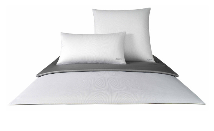 Vorderansicht eines Bettes mit Joop Mako-Satin Kissenbezug 40x80 cm, einer grauen Decke und einer weißen Bettdecke.