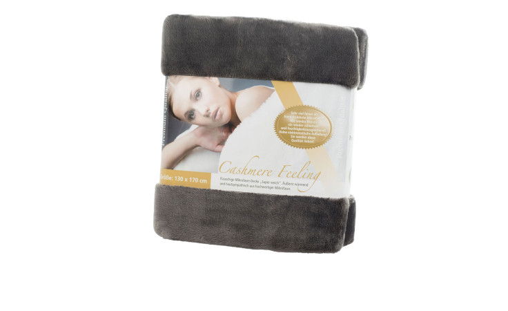 Gözze Wohndecke Premium Cashmere Feeling, 130 x 170 cm, gefaltet in Verpackung mit Etikett, das eine Frau zeigt.