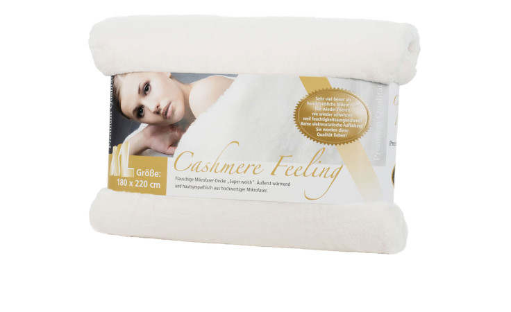Eine gerollte Gözze Wohndecke Premium Cashmere Feeling 180x220cm mit einem Etikett, das eine Frau und den Text "Cashmere Feeling" zeigt.