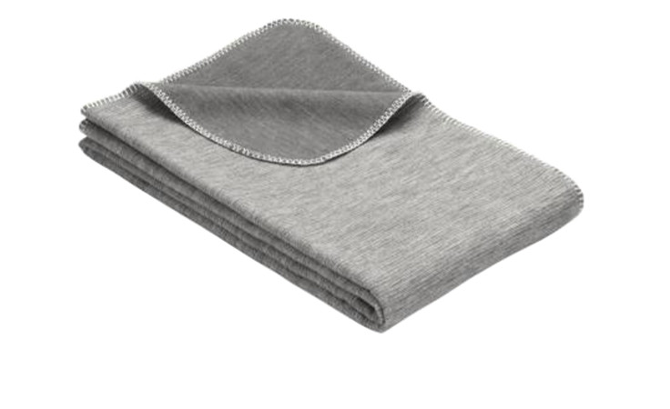 Eine gefaltete Baumwolldecke 140 x 200 cm mit weiß genähten Rändern, abgebildet auf weißem Hintergrund.