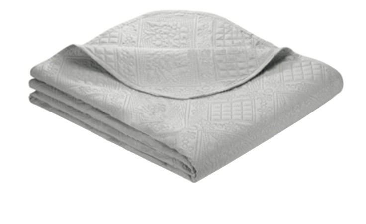 Fein säuberlich gefaltete Tagesdecke 220 x 250 cm in silberfarbener, hellgrauer Synthetikfaser mit geprägtem Geo-Blumenmuster.