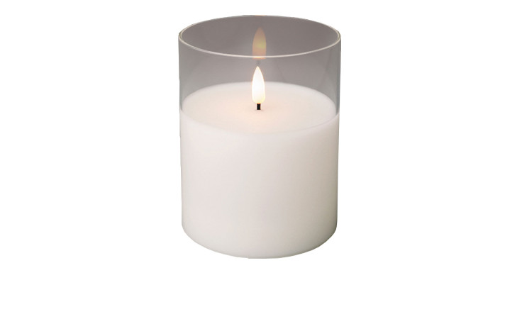 Eine LED-Wachskerze im Glas 12,5 cm mit einer einzelnen Flamme, isoliert auf einem weißen Hintergrund.