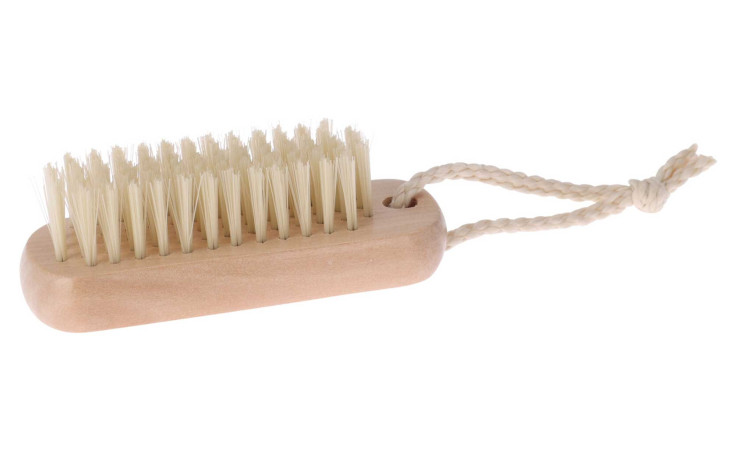 Die Nagelbürste hat weiße Borsten und eine geflochtene Kordel, die auf weißem Grund steht.