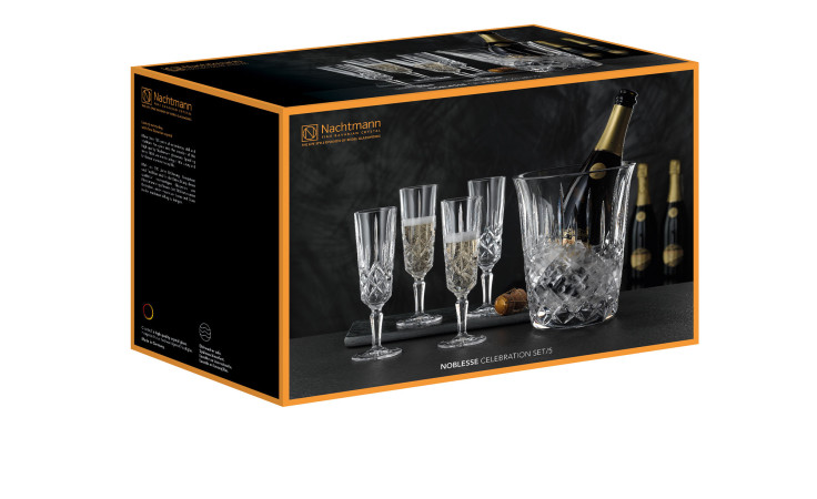 Ein Sektglas-Set Noblesse 5-tlg. Box mit klaren Kristallgläsern und einem Champagner-Eimer mit Flaschen dahinter.