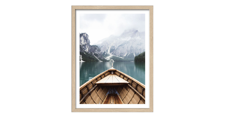 Das Pro-Art Rahmenbild Bootsfahrt auf Bergsee 33 x 43 cm zeigt ein Holzboot auf einem ruhigen See mit Bergen und Nebel.