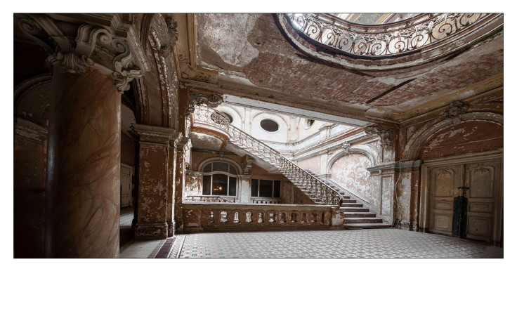 Ein verziertes, verlassenes Gebäude mit dem Alubild The Old Castle 50x100 cm von Pro-Art, einer großen Treppe und Metallgeländern.