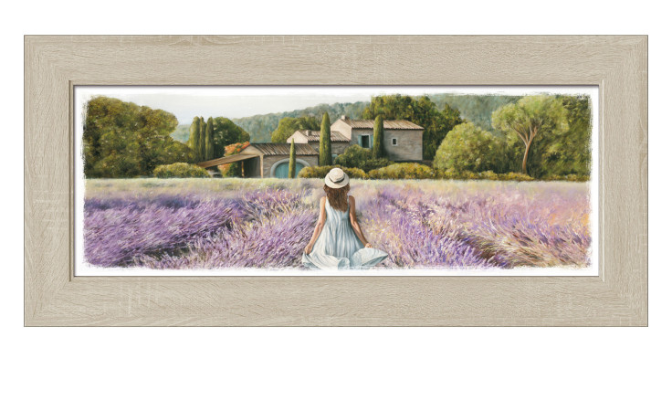 Eine Frau in einem weißen Kleid sitzt in einem Lavendelfeld und blickt auf ein Haus mit Pro-Art Rahmenbild Durch das Lavendelfeld.