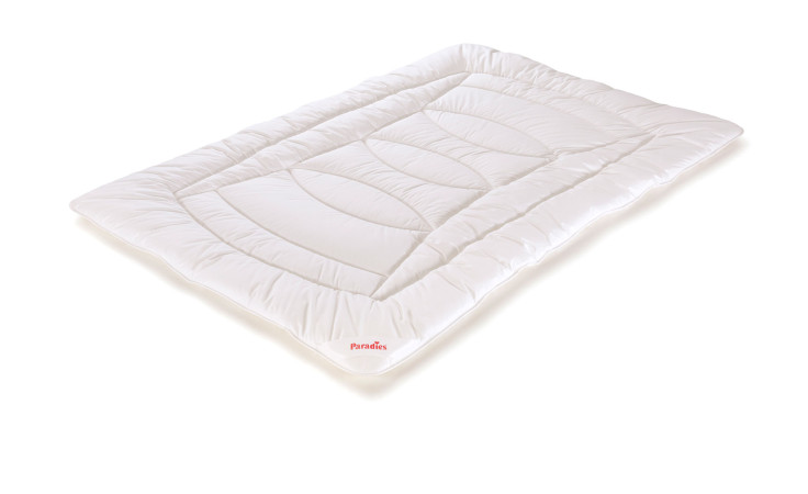 Eine rechteckige weiße Paradies Nima Bio Matratzenauflage, 155x220 cm, mit Naturfaserfüllung und rotem Etikett.