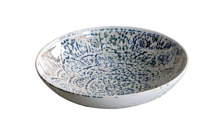 Der Teller Luigi von Ritzenhoff ist ein mehrfarbiger Steinzeugteller mit blauen und grünen Mustern auf Weiß.