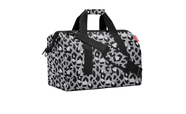 Reisenthel Reisetasche Allrounder L mit schwarzem und weißem Leopardenmuster, schwarzen Griffen und einem Schulterriemen.