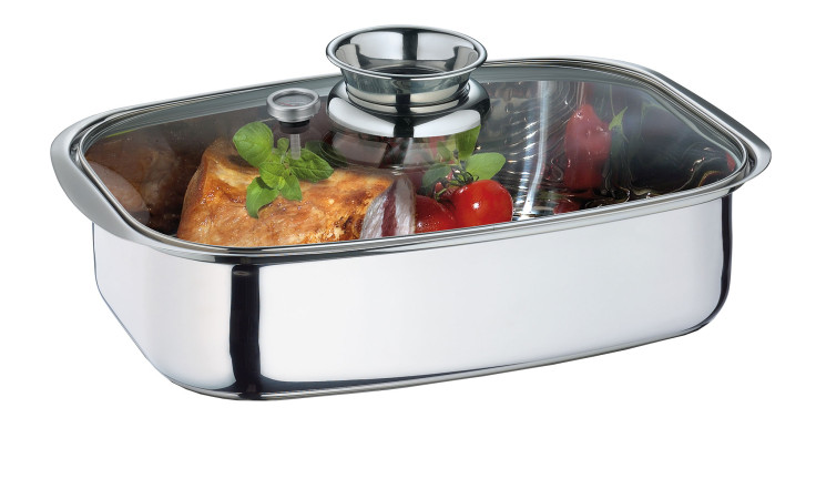 Küchenprofi Aromabräter / Dampfgarer Koch in silberfarben mit Glasdeckel, der Fleisch, Tomaten & Kräuter im Inneren röstet.