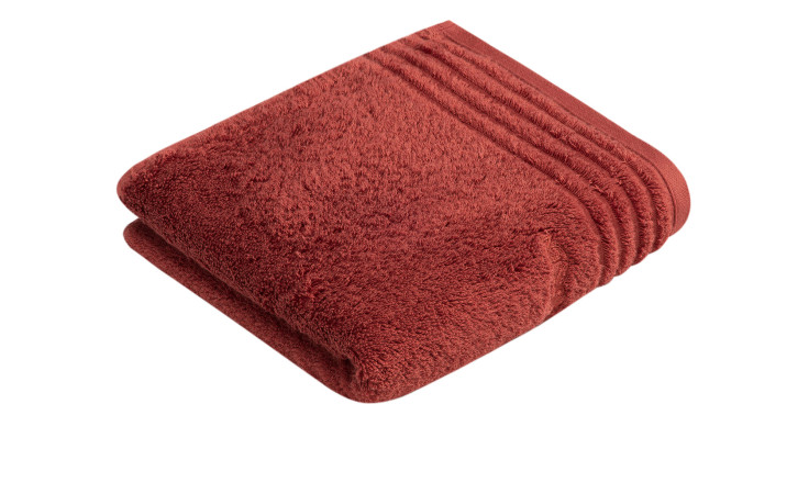 Ein gefaltetes, terrafarbenes Handtuch Vienna Style Supersoft 50 x 100 cm von Vossen ruht auf einem weißen Hintergrund.