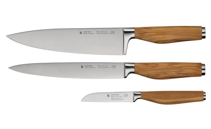 Das WMF Messerset Grand Wood 3-tlg. hat Klingen aus rostfreiem Stahl und helle Olivenholzgriffe auf weißem Grund.