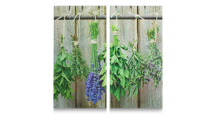 Bündel von frischen, bunten Kräutern hängen kopfüber über der Herdabdeck-/Schneideplatte 30 x 52 cm an einem rustikalen Zaun.