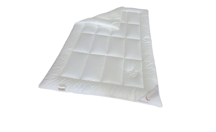 Die Schlafmond Ganzjahresdecke Lilly 135x200 cm zeigt weiße gesteppte Quadrate, die teilweise auf weißem Grund gefaltet sind.