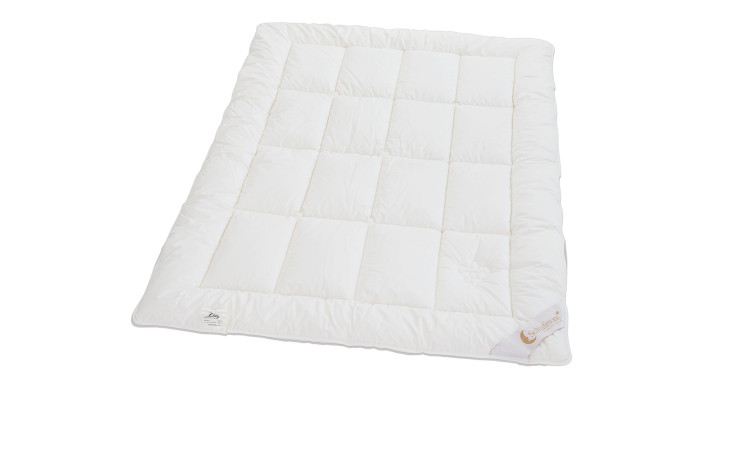 Eine weiße Schlafmond Sommerdecke Lilly 135 x 200 cm mit einem Ecketikett, abgebildet auf einem sauberen weißen Hintergrund.