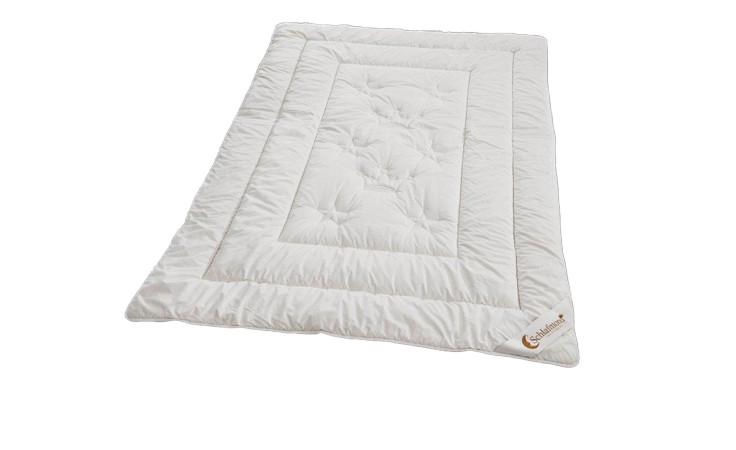 Ein weißes, rechteckiges Schlafmond Duo-Steppbett Der kleine Prinz 155x220cm mit einem gestickten Muster und Ecklogo.