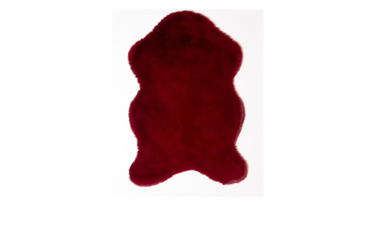 Ein unregelmäßig geformter Kunstfellteppich 60 x 90 cm aus Kunstfaser auf einem schlichten weißen Hintergrund.