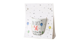 Ein Becher 330 ml aus Keramik mit Aufdruck "Du bist 50", Luftballons und Konfetti auf weißem Hintergrund.