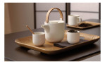 Eine Keramik-Teekanne und zwei Tassen auf dem ASA Selection Holz-Tablett Wood 45x36cm, mit Teeblättern und Zubehör.