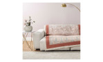 Beigefarbenes Sofa mit Bassetti Plaid Indian Roses Decke, goldene Stehlampe und Beistelltisch mit Vase vor einer hellen Wand.
