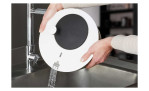 Jemand schüttet Wasser aus dem weißen Deckel einer GEFU Salatschleuder Rotare mit eingebautem Sieb in die Spüle.