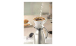 Heißes Wasser fließt in den GEFU Kaffeefilter Sandro Größe 4 über eine Karaffe, um auf der Theke Kaffee im Überguss zuzubereiten.