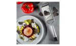 Geschnittenes Gemüse mit Sauce und Trüffelspänen neben einer GEFU Gourmet-Hobel Primeline und einer ganzen Tomate.