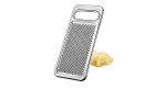 Die GEFU Kartoffelreibe Retaro mit Griff sitzt auf geriebenem Ingwer, ideal für die Küchendekoration, auf einem weißen Hintergrund.