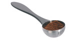 Die GEFU Kaffeemaß Misurino, gefüllt mit gemahlenem Kaffee, hat einen schwarzen Kunststoffgriff und eine Metallschaufel.