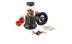 GEFU Salz- oder Pfeffermühle X-Plosion S mit Keramik-Mechanismus, Pfefferkörnern, Tomaten und rosa Salz auf weißem Hintergrund.