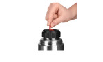 Eine Hand hebt eine rote Lasche auf dem schwarzen Deckel einer Emsa Isolierflasche Senator 700 ml aus Edelstahl.
