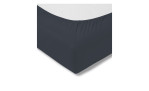 Nahaufnahme eines Estella Jersey-Spannbettlakens 100 x 200 cm in dunkel-marinefarbener Baumwolle, glatt über die Matratzenecke gelegt.