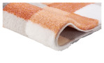 Badteppich Caro übergeschlagen. Der Teppich hat ein kariertes Design mit Orange, Weiß und Grau. 