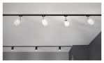 Spot URail 11 cm aus schwarzem Metall und Kunststoff mit vier verstellbaren Strahlern an einer weißen Decke über einem Minimalraum.