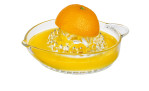 Eine Orangenhälfte auf der Küchenprofi-Zitruspresse, deren frischer Saft im Behälter darunter aufgefangen wird.