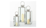 Drei Laternen Laterne Caruso 49 cm aus silberfarbenem Glas & Metall, jede mit einer leuchtenden weißen Stumpenkerze im Inneren.