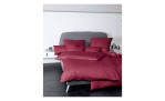 Mako-Satin Kissenbezug Colorsin der Größe 40 x 60 cm und in der Farbausführung rot, auf einem Bett bezogen mit der passenden ettwäsche und weiteren Kissen