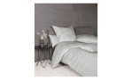 Minimalistisches Schlafzimmer mit grauer Satin-Bettwäsche Milano 155 x 220 cm, Naturfaser-Kissen, Nachttisch und Vase mit Trockenblumen.