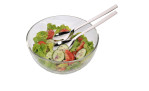 Eine Glasschüssel mit Salat und WMF Servier-Set Nuova Edelstahlutensilien auf weißem Hintergrund.